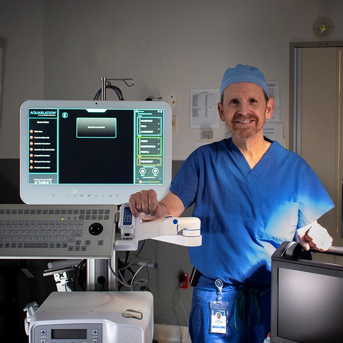 Arnold Sarazen, MD, Chief of Surgery and Urology at South County Health stands with the AquaBeam system.